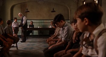 Movie still from “The Devil's Backbone” (2001), directed by Guillermo del Toro – A group of young people sitting in a room; Wide shot, Over the shoulder angle