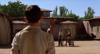 Movie still from “The Devil's Backbone” (2001), directed by Guillermo del Toro – A group of people standing around a table; Wide shot, Low angle