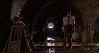 Movie still from “The Devil's Backbone” (2001), directed by Guillermo del Toro – A man standing inside of an arched building; Wide shot, Low angle