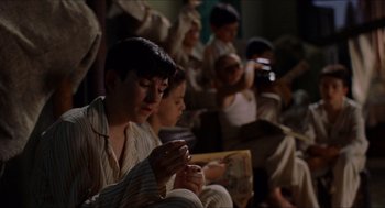 Movie still from “The Devil's Backbone” (2001), directed by Guillermo del Toro – A group of young people sitting in a room; Medium shot, High angle