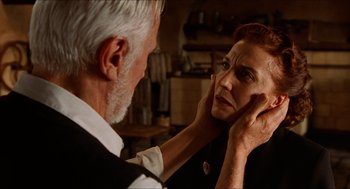 Movie still from “The Devil's Backbone” (2001), directed by Guillermo del Toro – An older man touching a woman's face in front of a mirror; Close Up shot, Over the shoulder angle