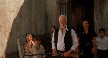 Movie still from “The Devil's Backbone” (2001), directed by Guillermo del Toro – An old man holding a rifle in front of a group of people; Medium shot, Low angle