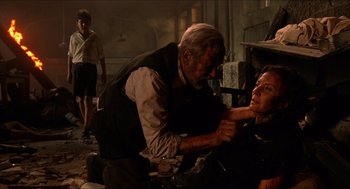Movie still from “The Devil's Backbone” (2001), directed by Guillermo del Toro – A man with a knife in his mouth and another man with a knife in his mouth; Medium shot, Over the shoulder angle