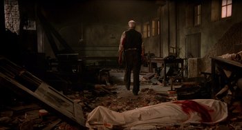Movie still from “The Devil's Backbone” (2001), directed by Guillermo del Toro – An old man walking through a room with a body lying on the floor; Wide shot, Low angle