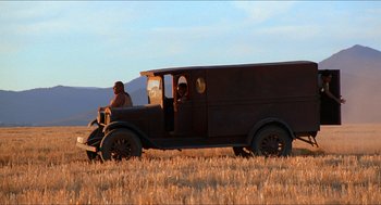 Movie still from “The Devil's Backbone” (2001), directed by Guillermo del Toro – An old truck is driving through a field; Wide shot, Low angle