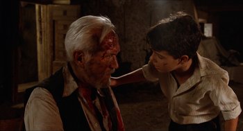 Movie still from “The Devil's Backbone” (2001), directed by Guillermo del Toro – A man with a bloody face and a boy with a fake head; Close Up shot, Over the shoulder angle