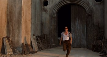 Movie still from “The Devil's Backbone” (2001), directed by Guillermo del Toro – A man walking in front of an old building; Wide shot, High angle