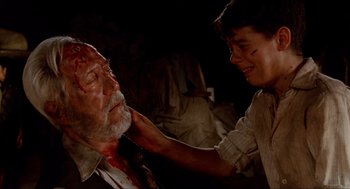 Movie still from “The Devil's Backbone” (2001), directed by Guillermo del Toro – A young man is getting his face waxed by an older man; Close Up shot, Over the shoulder angle