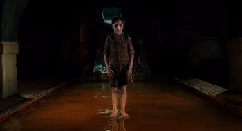 Movie still from “The Devil's Backbone” (2001), directed by Guillermo del Toro – A young boy standing in the middle of a pool of water at night; Wide shot, High angle