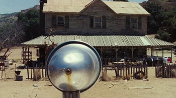 Movie still from “The Devil's Rejects” (2005), directed by Rob Zombie – An old parking meter in front of an abandoned house; Wide shot, Low angle