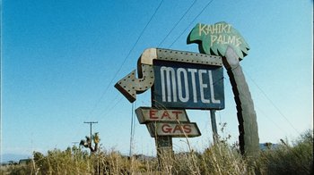 Movie still from “The Devil's Rejects” (2005), directed by Rob Zombie – An old motel sign in the middle of a field; Wide shot, Low angle