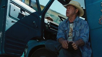 Movie still from “The Devil's Rejects” (2005), directed by Rob Zombie – A man sitting in the drivers seat of a truck; Medium shot, Low angle
