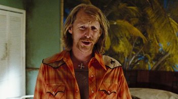Movie still from “The Devil's Rejects” (2005), directed by Rob Zombie – A man with long blonde hair wearing a plaid shirt; Close Up shot, Over the shoulder angle