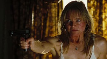 Movie still from “The Devil's Rejects” (2005), directed by Rob Zombie – A woman is holding a gun in a room; Close Up shot, Low angle