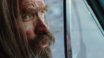 Movie still from “The Devil's Rejects” (2005), directed by Rob Zombie – A person with long hair and a long beard; Close Up shot, Low angle
