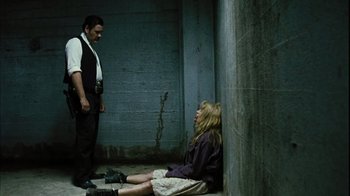 Movie still from “The Devil's Rejects” (2005), directed by Rob Zombie – A man and a woman sitting on the ground in a room; Wide shot, Low angle
