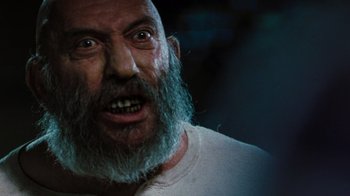 Movie still from “The Devil's Rejects” (2005), directed by Rob Zombie – An old man with a beard is looking at the camera; Close Up shot, Low angle