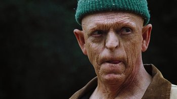 Movie still from “The Devil's Rejects” (2005), directed by Rob Zombie – An old man wearing a green hat and looking at the camera; Close Up shot, Low angle