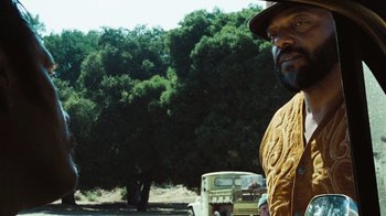 Movie still from “The Devil's Rejects” (2005), directed by Rob Zombie – A man standing in front of a truck on a dirt road; Close Up shot, Low angle