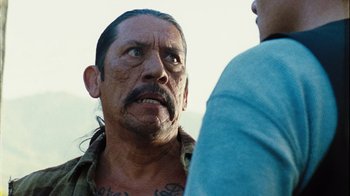 Movie still from “The Devil's Rejects” (2005), directed by Rob Zombie – A man with a beard and a mustache is talking to another man; Close Up shot, Over the shoulder angle