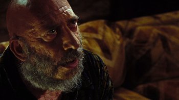 Movie still from “The Devil's Rejects” (2005), directed by Rob Zombie – An old man with a beard and a mustache looking at the camera; Close Up shot, Over the shoulder angle