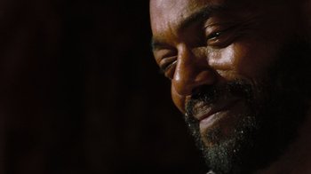 Movie still from “The Devil's Rejects” (2005), directed by Rob Zombie – A man with a beard smiling for the camera; Extreme Close Up shot, Low angle