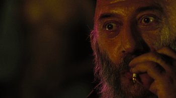 Movie still from “The Devil's Rejects” (2005), directed by Rob Zombie – A man with a long beard smoking a cigarette in a dark room; Extreme Close Up shot, Low angle