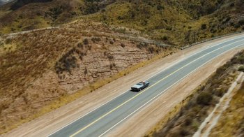 Movie still from “The Devil's Rejects” (2005), directed by Rob Zombie – A car driving down a road near a mountain; Extreme Wide shot, High angle