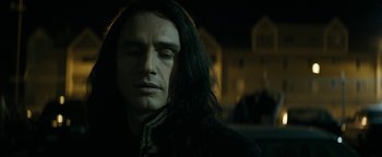 Movie still from “The Disaster Artist” (2017), directed by James Franco – A man with long black hair is looking at the camera; Close Up shot, Low angle