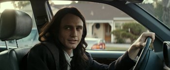 Movie still from “The Disaster Artist” (2017), directed by James Franco – A man with long hair sitting in the driver's seat of a car; Close Up shot, Over the shoulder angle