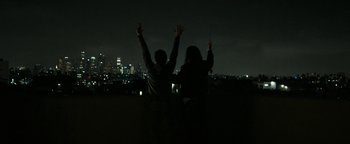Movie still from “The Disaster Artist” (2017), directed by James Franco – Two people standing in the dark with their hands raised; Wide shot, Low angle