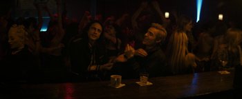 Movie still from “The Disaster Artist” (2017), directed by James Franco – Two men sitting at a bar and one is clapping his hands; Medium shot, Over the shoulder angle