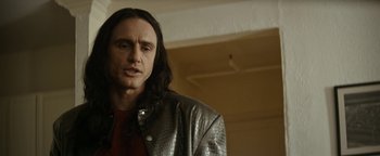 Movie still from “The Disaster Artist” (2017), directed by James Franco – A man with long black hair wearing a leather jacket; Close Up shot, Over the shoulder angle