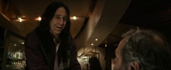 Movie still from “The Disaster Artist” (2017), directed by James Franco – A man with long black hair talking to another man; Close Up shot, Over the shoulder angle