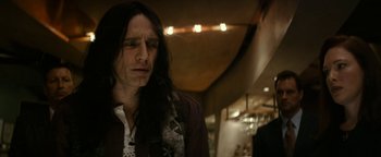 Movie still from “The Disaster Artist” (2017), directed by James Franco – A man with long black hair wearing a scarf; Close Up shot, Low angle