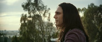 Movie still from “The Disaster Artist” (2017), directed by James Franco – A person with long black hair; Close Up shot, Over the shoulder angle