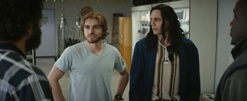 Movie still from “The Disaster Artist” (2017), directed by James Franco – Two men standing next to each other in a room; Medium shot, Over the shoulder angle