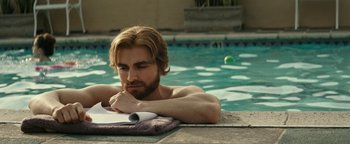 Movie still from “The Disaster Artist” (2017), directed by James Franco – A man leaning on the edge of a swimming pool; Close Up shot, High angle