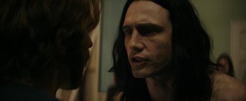 Movie still from “The Disaster Artist” (2017), directed by James Franco – A man with long black hair is looking at another man with long black hair; Close Up shot, Over the shoulder angle