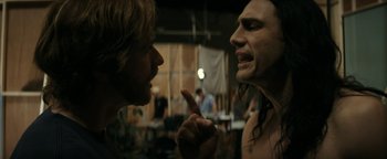 Movie still from “The Disaster Artist” (2017), directed by James Franco – A man with long white hair and a man with long black hair; Medium shot, Over the shoulder angle