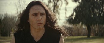 Movie still from “The Disaster Artist” (2017), directed by James Franco – A person with long black hair; Close Up shot, Over the shoulder angle