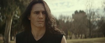 Movie still from “The Disaster Artist” (2017), directed by James Franco – A person with long black hair; Close Up shot, Over the shoulder angle