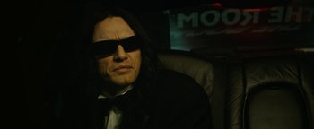 Movie still from “The Disaster Artist” (2017), directed by James Franco – A man with long black hair wearing sunglasses; Close Up shot, Low angle