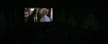 Movie still from “The Disaster Artist” (2017), directed by James Franco – People are sitting in a theater watching a movie; Wide shot, Over the shoulder angle