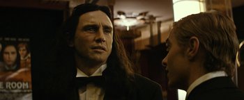Movie still from “The Disaster Artist” (2017), directed by James Franco – A man with long hair wearing a suit and tie; Close Up shot, Over the shoulder angle