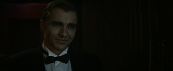 Movie still from “The Disaster Artist” (2017), directed by James Franco – A man in a suit and bow tie smiling for the camera; Close Up shot, Over the shoulder angle