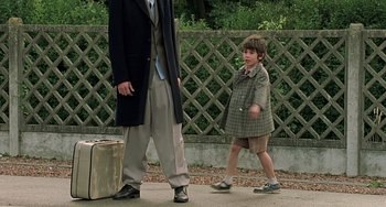 Movie still from “The Diving Bell and the Butterfly” (2007), directed by Julian Schnabel – A young boy is walking next to an older man; Medium shot, Low angle
