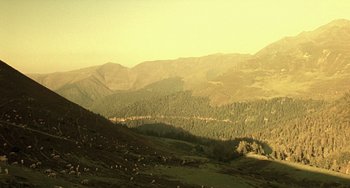 Movie still from “The Diving Bell and the Butterfly” (2007), directed by Julian Schnabel – A view of a mountain range from a distance; Extreme Wide shot, High angle