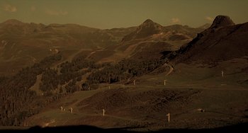 Movie still from “The Diving Bell and the Butterfly” (2007), directed by Julian Schnabel – A view of a mountain range at sunset; Extreme Wide shot, High angle