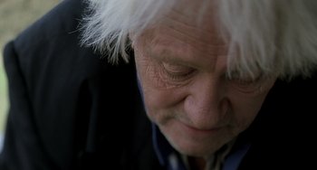 Movie still from “The Diving Bell and the Butterfly” (2007), directed by Julian Schnabel – An older man with white hair looking down at the ground; Extreme Close Up shot, Low angle